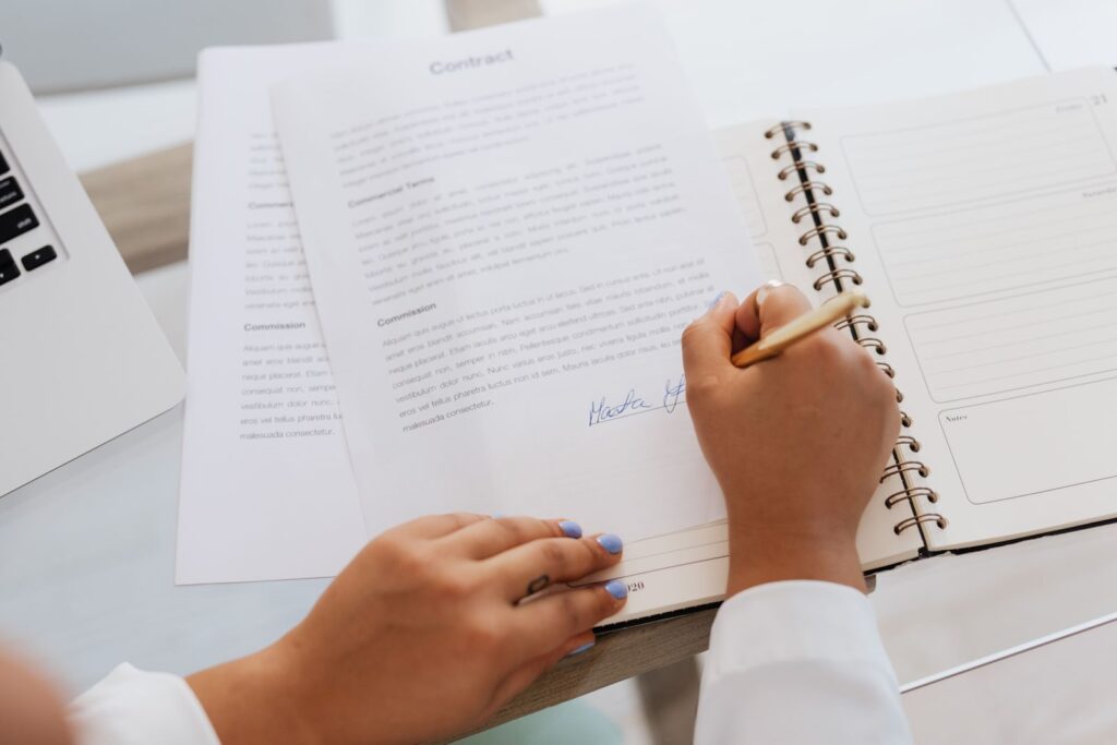 Close-up of hands signing a business contract on a desk